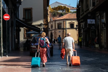 Dos turistas recorren con sus maletas la calle San Juan, en el centro de Oviedo, el pasado 18 de julio.