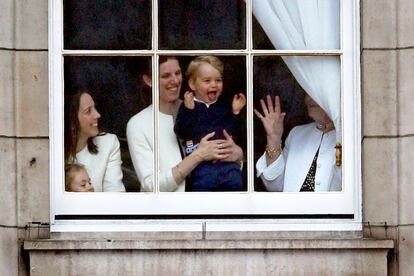 El príncipe Jorge mira a través de la ventana en Buckingham Palace, durante la celebración del Trooping The Colour en la ceremonia del 13 de junio de 2015. Tras él, María Teresa Turrión Torrallo, la española que cuida de los hijos de los duques de Cambridge, el mayor de ellos destinado a ser un día rey de Reino Unido.