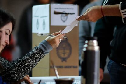Un hombre recibe su papeleta electoral este domingo en Buenos Aires (Argentina). La participación electoral de este domingo ha alcanzado el 75%, según ha anunciado el ministro del Interior, Rogelio Frigerio.