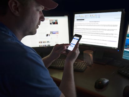 A man checks Facebook on his cellphone.