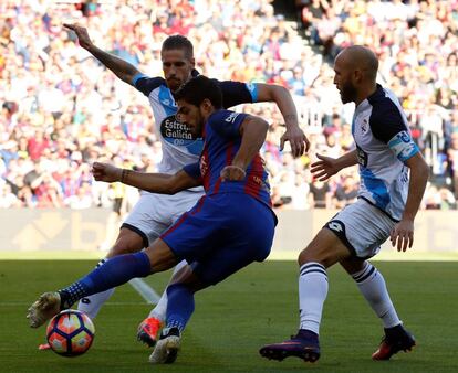 Luis Suarez defiende el balón ante los jugadores del Deportivo.