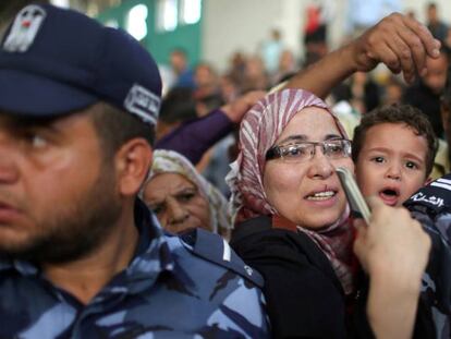 Una mujer con su hijo pide un visado en Gaza para cruzar a Egipto.