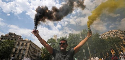 A taxi driver holds up smoke bombs during a strike against what they say is unfair competition from ride-hailing and car-sharing services such as Uber and Cabify in Barcelona