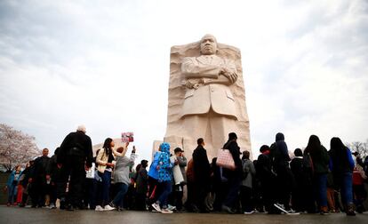 Un grupo de personas participa en una marcha silenciosa con motivo del cincuenta aniversario de la muerte de Martin Luther King, junto a su estatua en Washington.