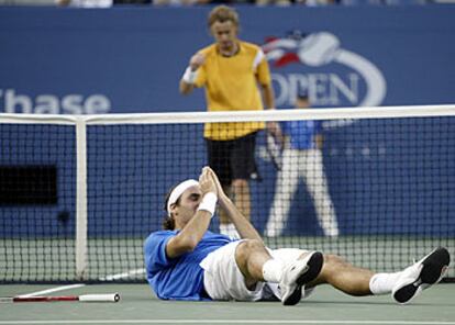 Hewitt se dirige a felicitar a Federer, caído de espaldas sobre la pista, al finalizar su partido.