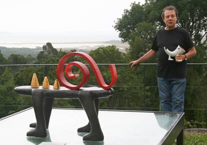 La escultura 'Arroba roja' delante de Porto, quien sostiene su creación 'Smartdog'. Al fondo, la playa de Carnota.