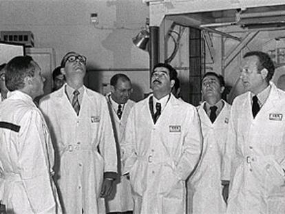 Chirac (con gafas) acompaña a Sadam (con bigote) en el recorrido de una planta nuclear francesa, en 1975.