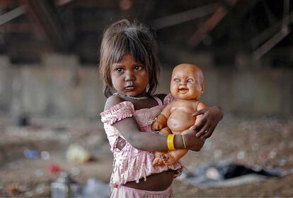 “INSTINTO MATERNAL”(19.5.2013). Ni los mocos, ni los harapos, ni la cara sucia de esta niña de India fue lo que atrajo la atención del periodista.En esta fotografía,  subraya el inconcebible instinto maternal de quien parece abandonado, especialmente con un muñeco de aspecto psicótico. 