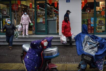 People wearing face masks leave after stocking up on food at a market in Wuhan on January 26.