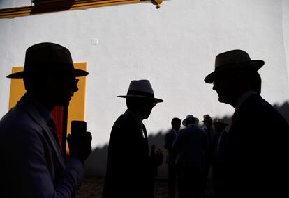 Las siluetas de varios hombres en la entrada de la plaza de toros de La Maestranza, en Sevilla, el lunes.