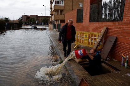 Un vecino retira agua del garaje de su edificio tras las fuertes lluvias en Ávila, este viernes.