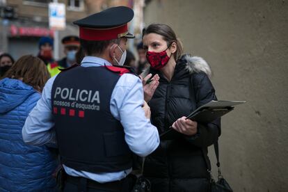 La secretaria judicial conversa con un agente de los Mossos d'Esquadra durante el desahucio paralizado en la calle Varsovia de Barcelona, el pasado 10 de diciembre.