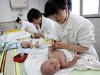 Unas enfermeras cuidan de unos bebés en un centro de infancia de Yongquan, en el sur de China.