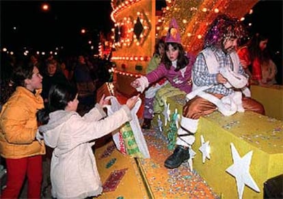 Una niña recibe caramelos en una de las carrozas que participaron ayer en la cabalgata de Reyes de Villa de Vallecas.