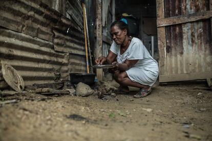 Carmen Feliz Mateo cocina la comida en su 'vivienda' del asentamiento de Canta La Rana. Lleva allí 'temporalmente' desde hace dos décadas, desde que el Georges arrasara su casa.