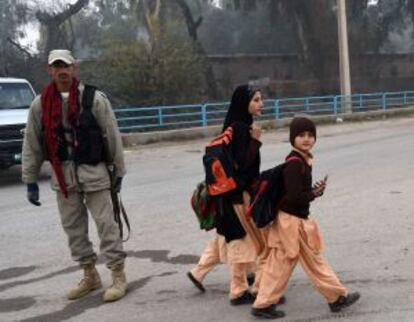 Los escolares vuelven a las aulas vigilados por las fuerzas de seguridad paquistaníes en Peshawar.