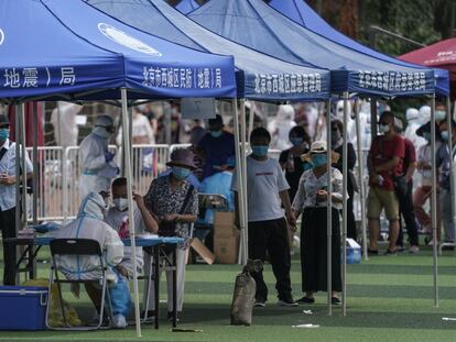 Residentes o gente que visitó el mercado de Xinfadi hacen cola para hacerse el test de coronavirus en Pekín, este lunes.