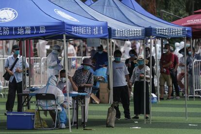Residentes o gente que visitó el mercado de Xinfadi hacen cola para hacerse el test de coronavirus en Pekín, este lunes.