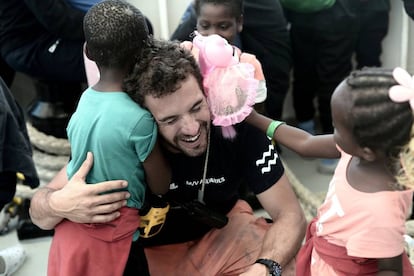 Un miembro de la tripulación abraza a un niño migrante a bordo del barco de rescate Aquarius antes de desembarcar en el puerto de Valencia, España, el 17 de junio de 2018.