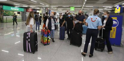 Viajeros alemanes atendidos por personal de TUI a su llegada al aeropuerto de Palma de Mallorca.