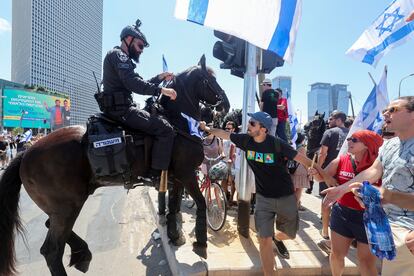 Manifestantes increpan a un policía montado a caballo durante las protestas en Tel Aviv, este martes. 