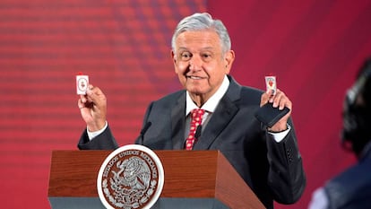 El presidente de México, Andrés Manuel López Obrador, muestra dos amuletos religiosos.