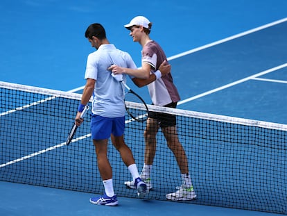 Italy's Jannik Sinner with Serbia's Novak Djokovic after winning his semi final match at Melbourne Park, Melbourne, Australia. January 26, 2024.