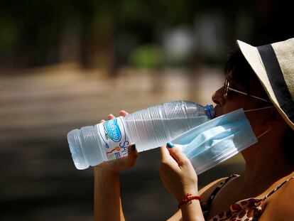 Una mujer bebe agua en Córdoba, durante la ola de calor de principio de agosto.