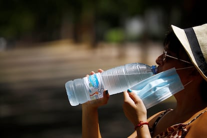 Una mujer bebe agua en Córdoba, durante la ola de calor de principio de agosto.