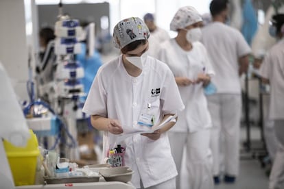 Una enfermera observa unos documentos antes de tratar a un paciente en la zona de semicríticos del hospital.