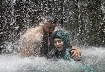 Una pareja de árabes israelíes se baña en una cascada durante la fiesta de Eid al-Fitr en el parque nacional Gan HaShlosha, cerca de la ciudad norteña israelí de Beit Shean.