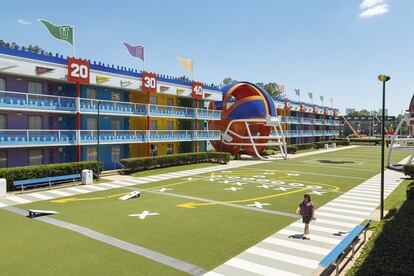 Una mujer pasea por la pista
de fútbol americano del
All-Star Sports Resort, con
un casco de dimensiones
descomunales en la fachada.