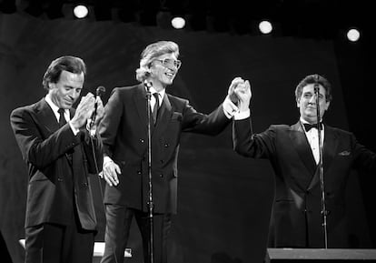 De izda. a dcha., el cantante Julio Iglesias, el compositor Manuel Alejandro y el tenor Plácido Domingo, saludan al público al finalizar el concierto celebrado en Sevilla en 1989.
