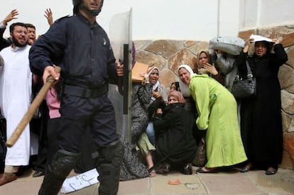 Unas mujeres se refugian de la batalla campal entre antidisturbios y estudiantes universitarios durante la protesta en Argel.