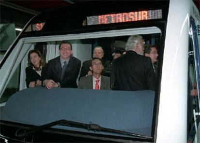 El presidente regional Alberto Ruiz-Gallardón, en la cabina de un convoy de metrosur, junto al alcalde de Madrid.