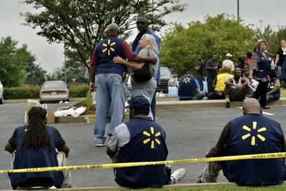 Empleados de Walmart se reúnen en un estacionamiento después de un tiroteo en la tienda en Misisipi (EE UU), este martes. Dos personas murieron y un agente de policía resultó herido en el siniestro occurrido esta mañana. El sheriff del condado de DeSoto, Bill Rasco, indicó que el sospechoso había sido herido de bala durante el tiroteo en la ciudad de Southhaven.
