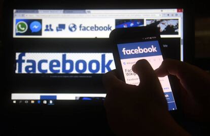 (FILES) In this file photo taken on March 22, 2018 a cellphone and a computer screen display the logo of the social networking site Facebook in Asuncion.  A US consumer protection agency said March 26, 2018 it has opened an investigation into Facebook for potentially failing to live up to its promises on privacy and possible violations of a consent decree.The Federal Trade Commission confirmed news reports from last week that it had opened an inquiry over the harvesting of Facebook data on tens of millions users of the social network by the British consulting group Cambridge Analytica.  / AFP PHOTO / NORBERTO DUARTE