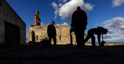 Unos vecinos trabajan en los aledaños de la iglesia de Santa María del Castillo de Castronuño.