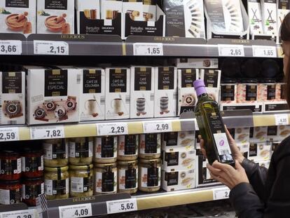 Una mujer compra una botella de aceite oliva extra en un supermercado de Madrid.