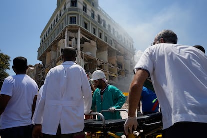 Un grupo de paramédicos prepara una camilla para transportar a alguno de los más de 30 heridos que ha dejado el siniestro.