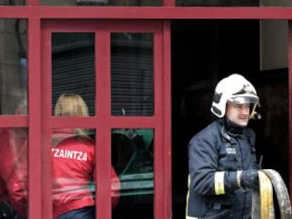 Un bombero sale del inmueble en que se ha registrado el incendio.