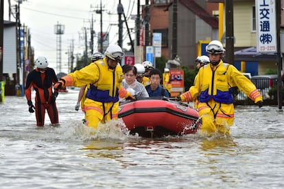 Miembros de los equipos de rescate evacúan a personas afectadas por las inundaciones en Oyama, en la prefectura de Tochigi, al norte de Tokio (Japón).