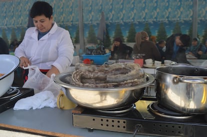 Una mujer prepara salchichas de carne y grasa de caballo, en un puesto de comida  en Taskent, capital de Uzbekistán.