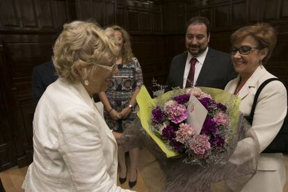 Manuela Carmena recibe un ramo de flores de los representantes de la Asociación de Vendedores de Prensa Profesionales de Madrid.