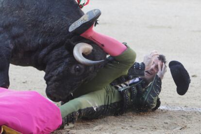 El primer toro de la tarde, <i>Aviadorito,</i> empitona a José Mora, subalterno de Rafaelillo.