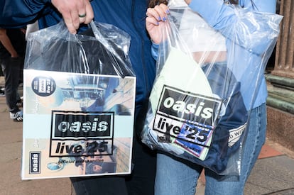 Dos fans muestran merchandising de la banda. 