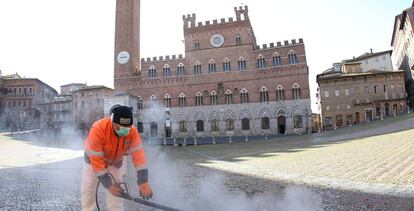 Un trabajador de saneamiento lleva a cabo la limpieza de la Plaza del Campo, en Siena, Italia.