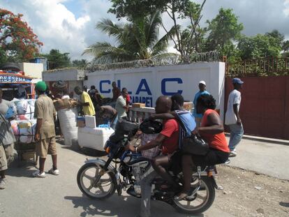 Una moto-taxi pasa por un mercado en la carretera que va hacia Cabo Haitiano.