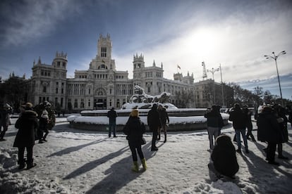 Uno de los problemas que se están encontrando los operarios es la presencia de un importante número de personas en las calles atraídas todavía por la nieve acumulada. En la imagen, el Ayuntamiento de Madrid. En primer término, la fuente de la diosa Cibeles preside la plaza.