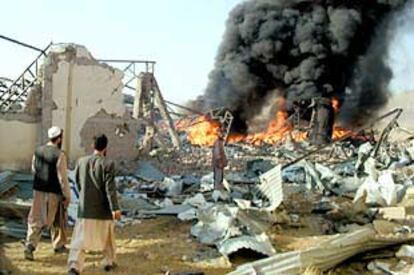 Dos trabajadores afganos de la Cruz Roja, ante el edificio de esta organización humanitaria destruido durante el bombardeo.